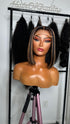 A mannequin head with a sleek, short bob wig styled in a middle part. The wig features dark brown hair with lighter brown highlights.